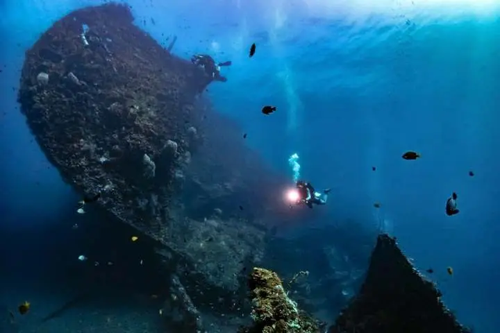 The USAT Liberty wreck underwater with a diver, Tulamben