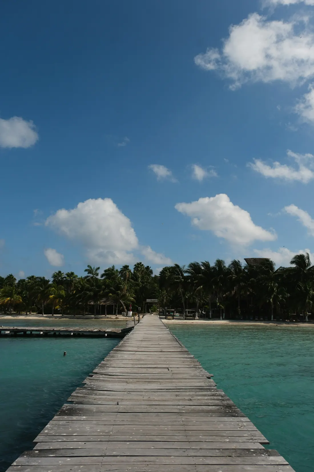 A wooden pier over clear turquoise water on Isla Mujeres