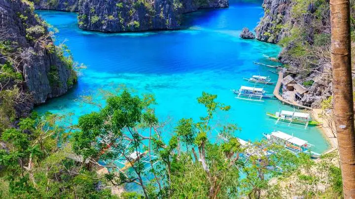 Turquoise lake surrounded by limestone cliffs, seen from above