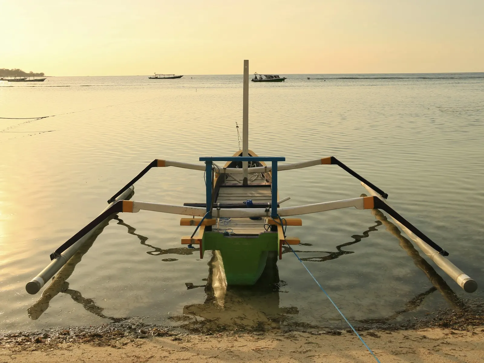 A traditional boat resting on clear turquoise water off Gili Air