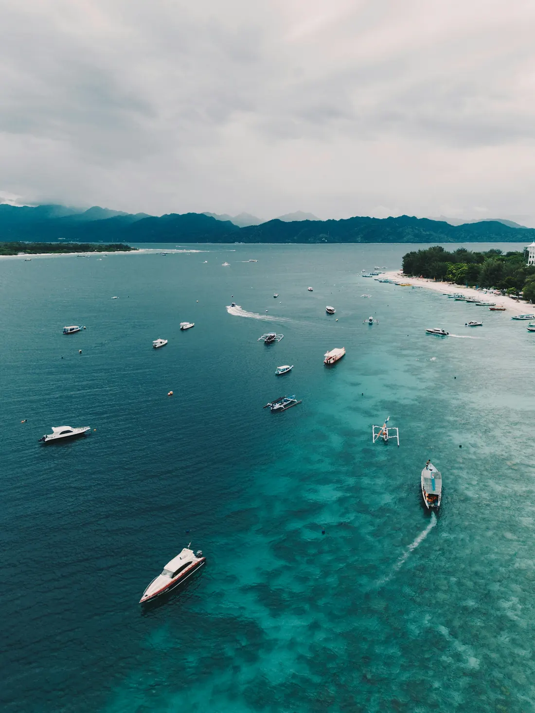 Local boats floating in clear water off Gili Trawangan