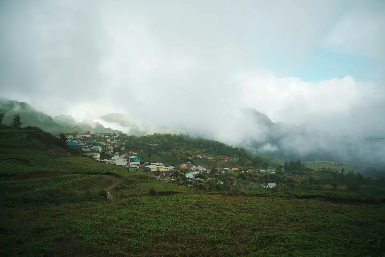 The village of Hell-Bourg in a green valley under low clouds, Salazie