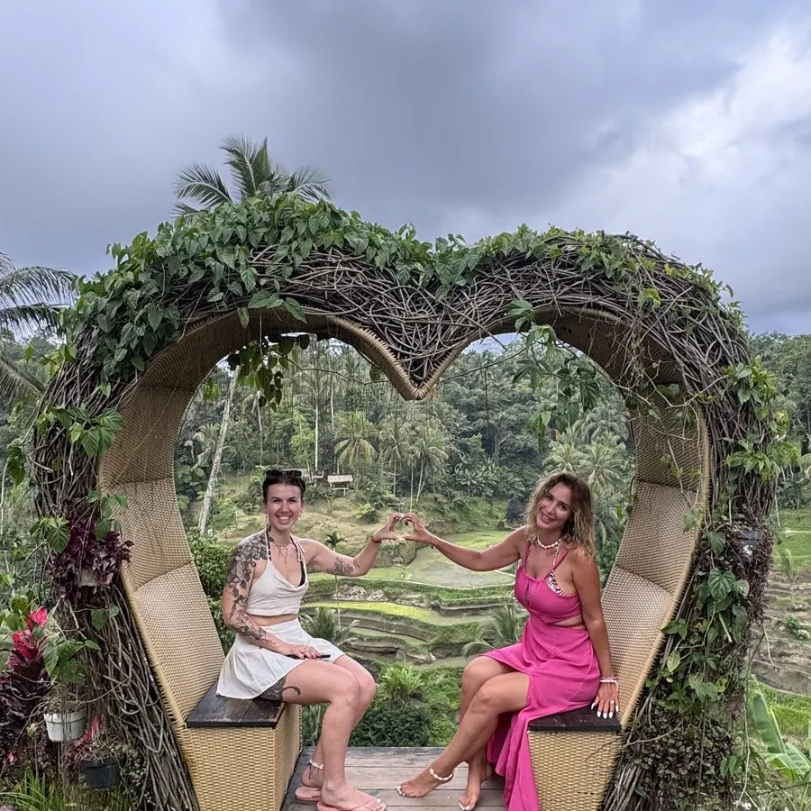 Rocío and a guest in a heart frame above green rice terraces